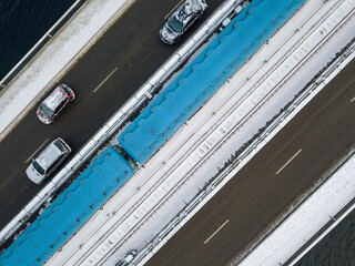 One metro train on a snow-covered metro bridge in Kiev. Cloudy winter morning. Aerial drone view.