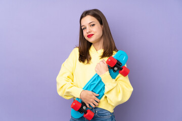 Teenager girl isolated on purple background with a skate with happy expression