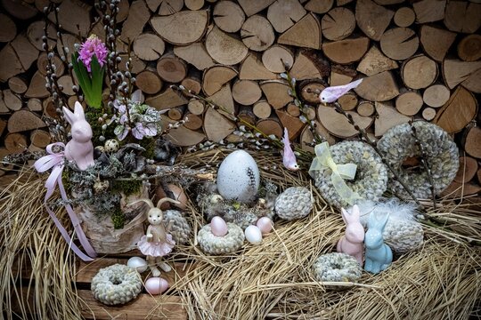 Easter bouquet composition with colorful eggs in nest on wooden background. Angement flower eco with copy space