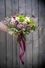 Bouquet of fresh delicate flowers on a dark shady blured background gift