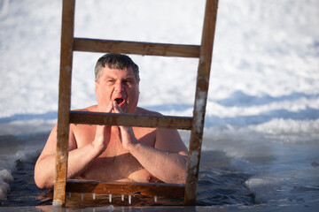 A man plunges into an ice-hole during the winter festival of the baptism of Jesus. A man swims in...