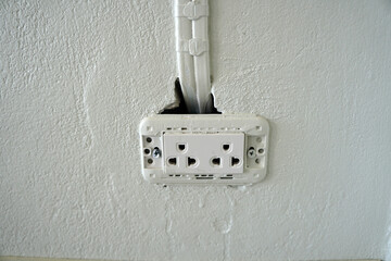 The power socket without cover was installed on the cement wall that was not properly installed.