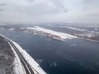 The Dnieper River in Kiev in a blizzard. Aerial drone view. Frosty winter cloudy morning.