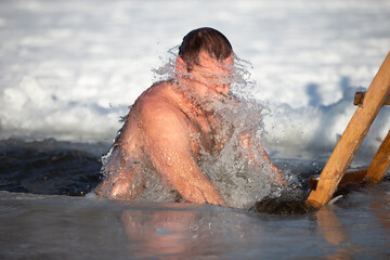 A man plunges into an ice-hole during the winter festival of the baptism of Jesus. A man swims in...