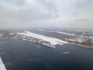 The Dnieper River in Kiev in a blizzard. Aerial drone view. Frosty winter cloudy morning.