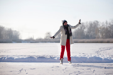 A woman goes ice skating in winter on an icy lake.