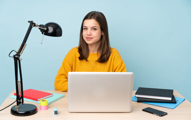 Student girl studying in her house isolated on blue background laughing