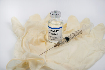 COVID-19 vaccine vial, syringe and medical rubber medicine bottle on white background with copy...