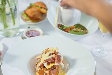 Eggs Benedict on toasted muffins with ham and sauce. Breakfast Buffet Concept, Breakfast Time. Various brunch on the table