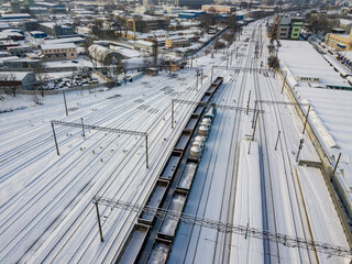 Snow-covered freight trains on rails in Kiev. Aerial drone view. Winter snowy morning.