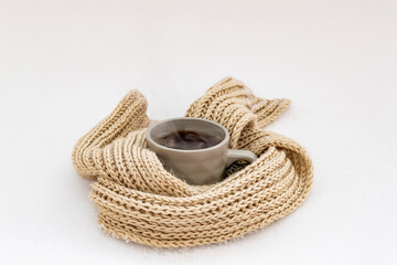 Obraz premium Thinking of you - card. Mug of tea with steam in a knitted scarf. 