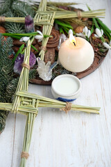 Fototapeta na wymiar Winter altar for Imbolc sabbath. spring pagan holiday ritual. Brigid's cross, milk, candle, wheel of the year, and snowdrops - symbols of Imbolc, spring equinox