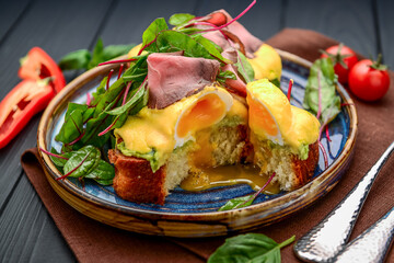 Eggs Benedict on toast with ham and sauce