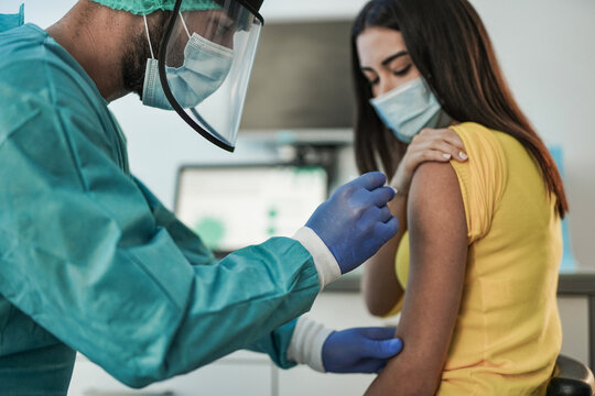 Male doctor vaccine a young woman patient - Vaccination against coronavirus pandemic