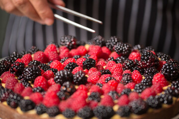 Chef cook preparing tart in his kitchen. Delicious raspberry  tart (tartlet) with whipped cream. Breakfast Buffet Concept, Breakfast Timeю. Various brunch on the table

