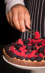 Chef cook preparing tart in his kitchen. Delicious raspberry  tart (tartlet) with whipped cream. Breakfast Buffet Concept, Breakfast Timeю. Various brunch on the table
