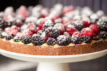 Chef cook preparing tart in his kitchen. Delicious raspberry  tart (tartlet) with whipped cream....