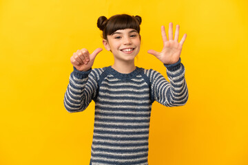 Little caucasian girl isolated on yellow background counting six with fingers