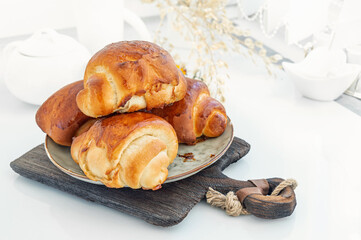Cinnamon buns Christmas baking buns on a wooden breakfast table on a plate. The freshest homemade cakes Close-up. copy space