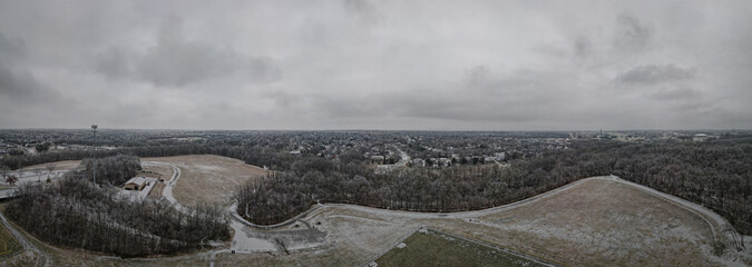 Aerial view toward neighborhoods of Lexington, Kentucky during icy overcast day with Veteran's park lawns on the foreground - obrazy, fototapety, plakaty