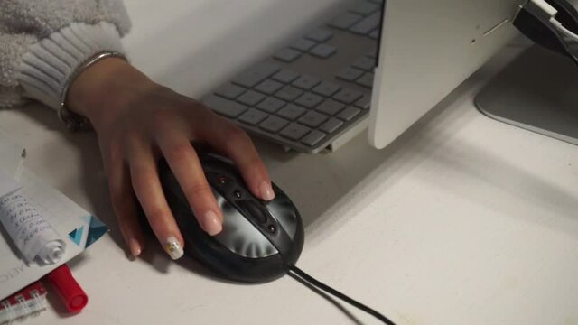the girl's hands work on a computer mouse