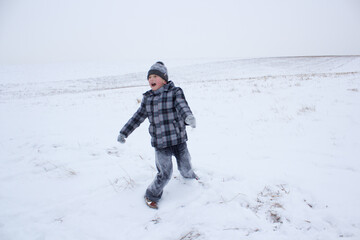 Fototapeta na wymiar boy screams in winter,in winter the boy is playing with snow, the boy is all in the snow