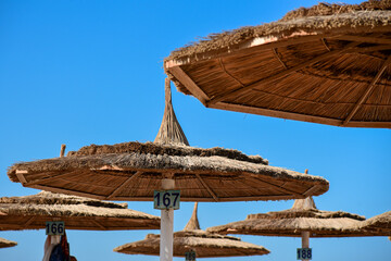 Reed beach umbrellas against the blue sky.