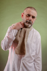 A hard-working elderly man in a vigorous state despite a sore throat wrapped in a scarf