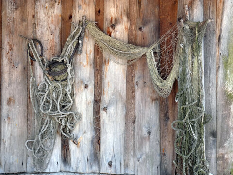 Old fishing net is hanging on the wood wall