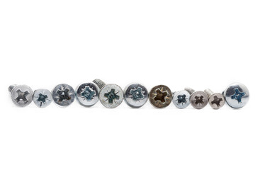 Caps of bolts and screws under the Phillips screwdriver on a white background