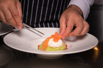 Chef cook preparing eggs in his kitchen. Eggs Benedict on toasted muffins with ham and sauce. Breakfast Buffet Concept, Breakfast Time. Various brunch on the table. 