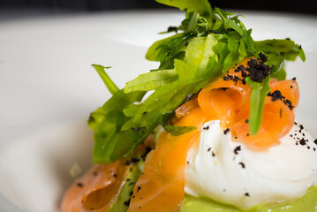Chef cook preparing eggs in his kitchen. Eggs Benedict on toasted muffins with ham and sauce. Breakfast Buffet Concept, Breakfast Time. Various brunch on the table. 