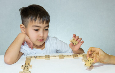 two children playing dominoes sitting in the living room childhood concept