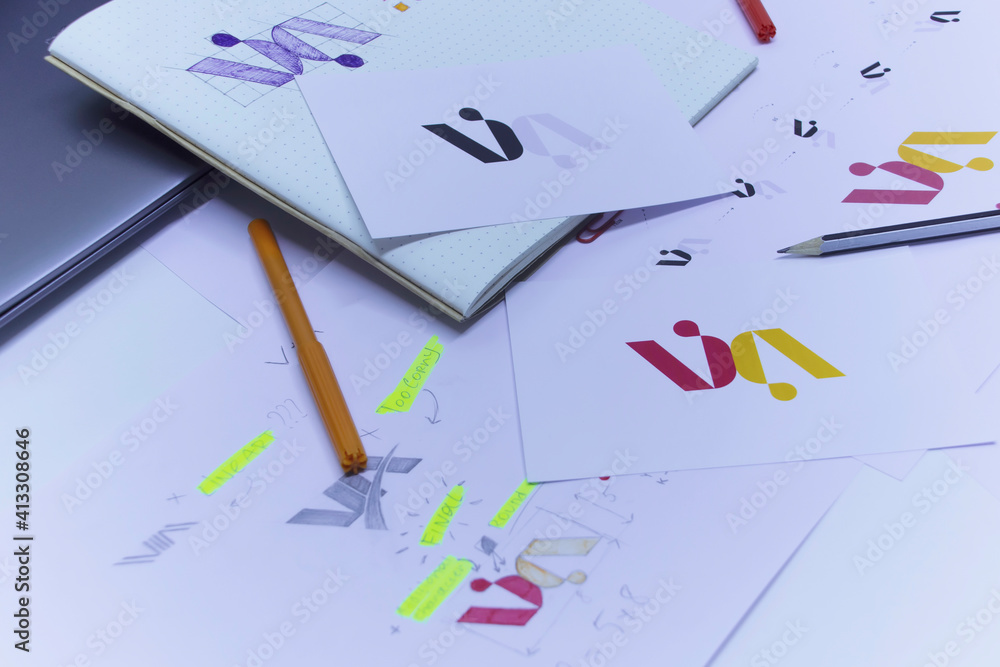 Poster sketches and drawings of the logo printed on paper. development of logo design in the studio on a ta