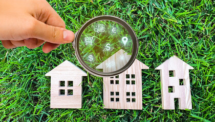 Realtor examines houses through a magnifying glass. Review of the real estate market, search for...