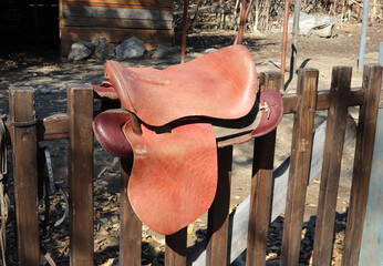 Leather saddle on the fence