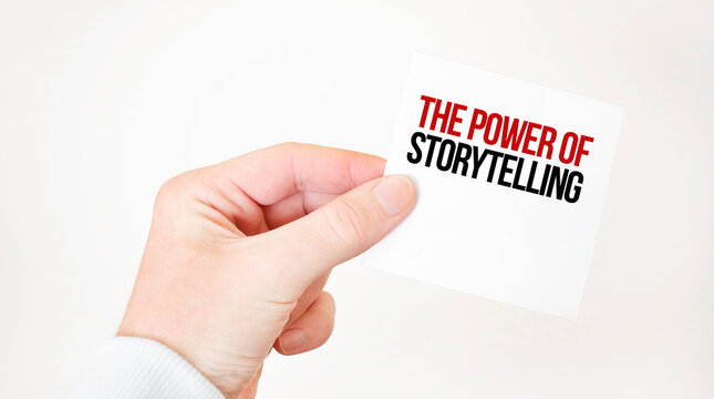 Businessman holding a card with text THE POWER OF STORYTELLING,business concept