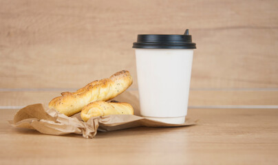 Two bun with poppy seeds with coffee cup on wood table. Breakfast. Good Morning