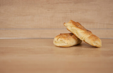 Two bun with poppy seeds on wood table