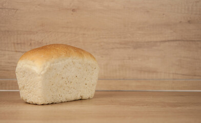 Fresh out of the oven loaf of homemade whole wheat bread on a wooden table