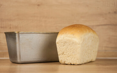 Homemade toasted whole wheat bread and metal form for bread
