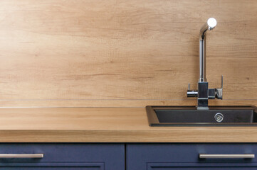 Black kitchen sink and Tap water in the kitchen. The interior of the kitchen room of the apartment....
