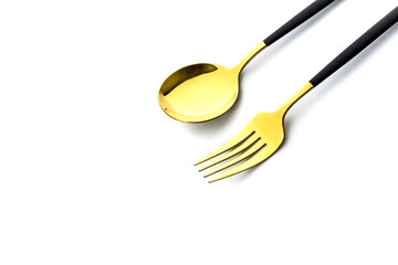 Golden fork and spoon close-up on white background. Flatware for food. Kitchen utensils.