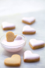 Dipping Mini Heart Shaped Sugar Cookies in Pink Icing