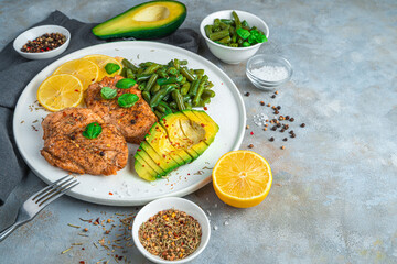 Fried chicken fillet, string beans and avocado on a gray background. Diet lunch. The concept of natural, organic food.