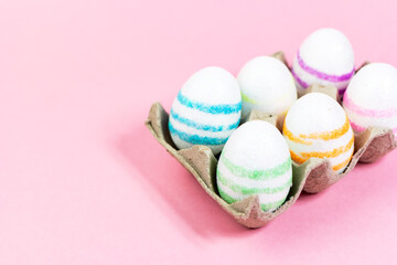 Colorful Easter eggs on a pink background. Copy space. Celebrating Easter