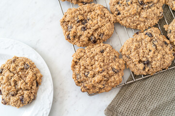 Homemade oatmeal raisin cookies cooling on a rack in the kitchen.