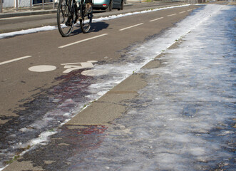 riding bicycle on city bike lanes in sunny winter time