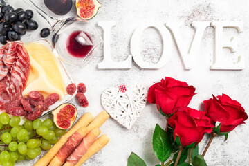 Valentines Day background with appetizers on table italian antipasto snacks and wine. Grape, figs, cheese, bread, prosciutto, meat snaks. Antipasti, gourmet, romantic concept