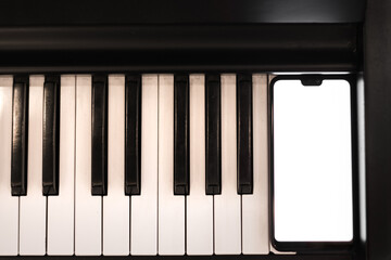 Naklejka premium smartphone and piano keys close up